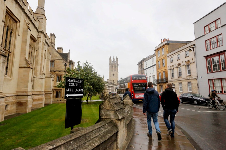 FILE - People walk around Oxford University's campus on Sept. 3, 2017, in Oxford, England. (AP Photo/Caroline Spiezio, File)