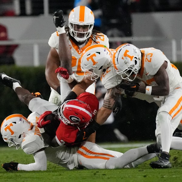 Georgia running back Nate Frazier (3) is stopped by Tennessee defensive back Andre Turrentine (2), defensive back Boo Carter (23) and linebacker Jeremiah Telander (22) during the first half of an NCAA college football game, Saturday, Nov. 16, 2024, in Athens, Ga. (AP Photo/John Bazemore)