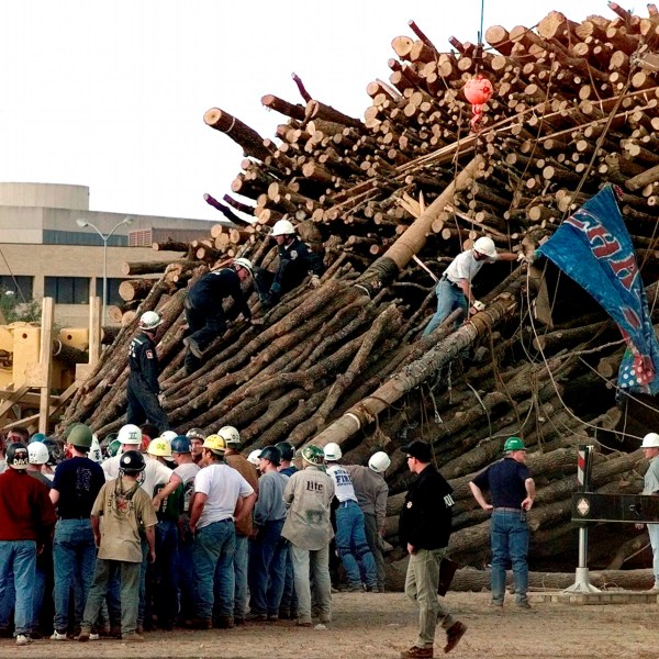 FILE - Texas A&M students and rescue workers gathered at the base of the collapsed bonfire stack as the search continues for victims in College Station, Texas, Nov. 18, 1999. (AP Photo/Pat Sullivan, File)