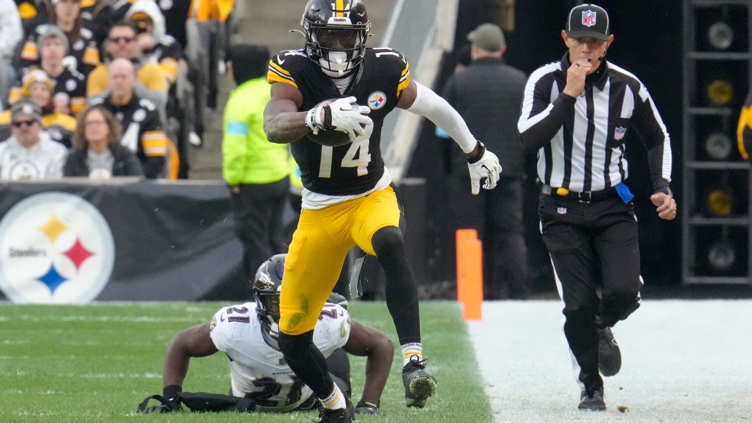 Pittsburgh Steelers wide receiver George Pickens (14) avoids a tackle by Baltimore Ravens cornerback Brandon Stephens (21) during the second half of an NFL football game, Sunday, Nov. 17, 2024, in Pittsburgh. (AP Photo/Gene J. Puskar)