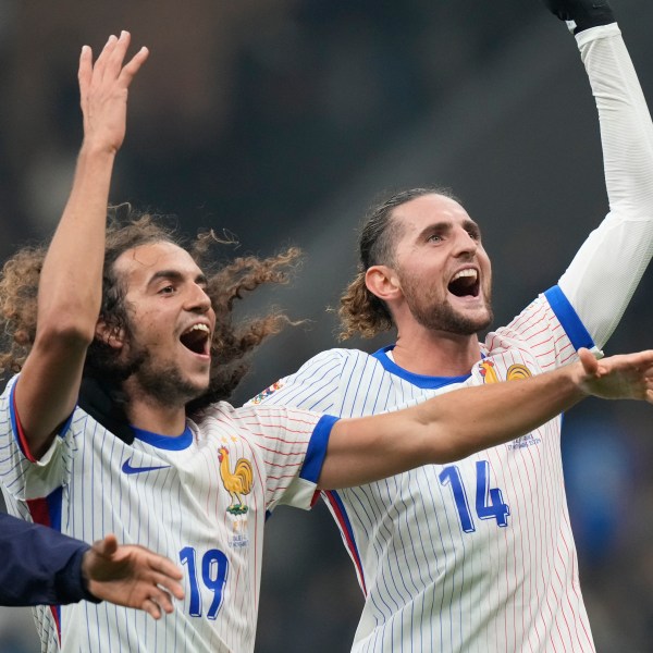 France's Adrien Rabiot, right, celebrates with Matteo Guendouzi after the Nations League soccer match between Italy and France, at the San Siro stadium in Milan, Italy, Sunday, Nov. 17, 2024. (AP Photo/Luca Bruno)