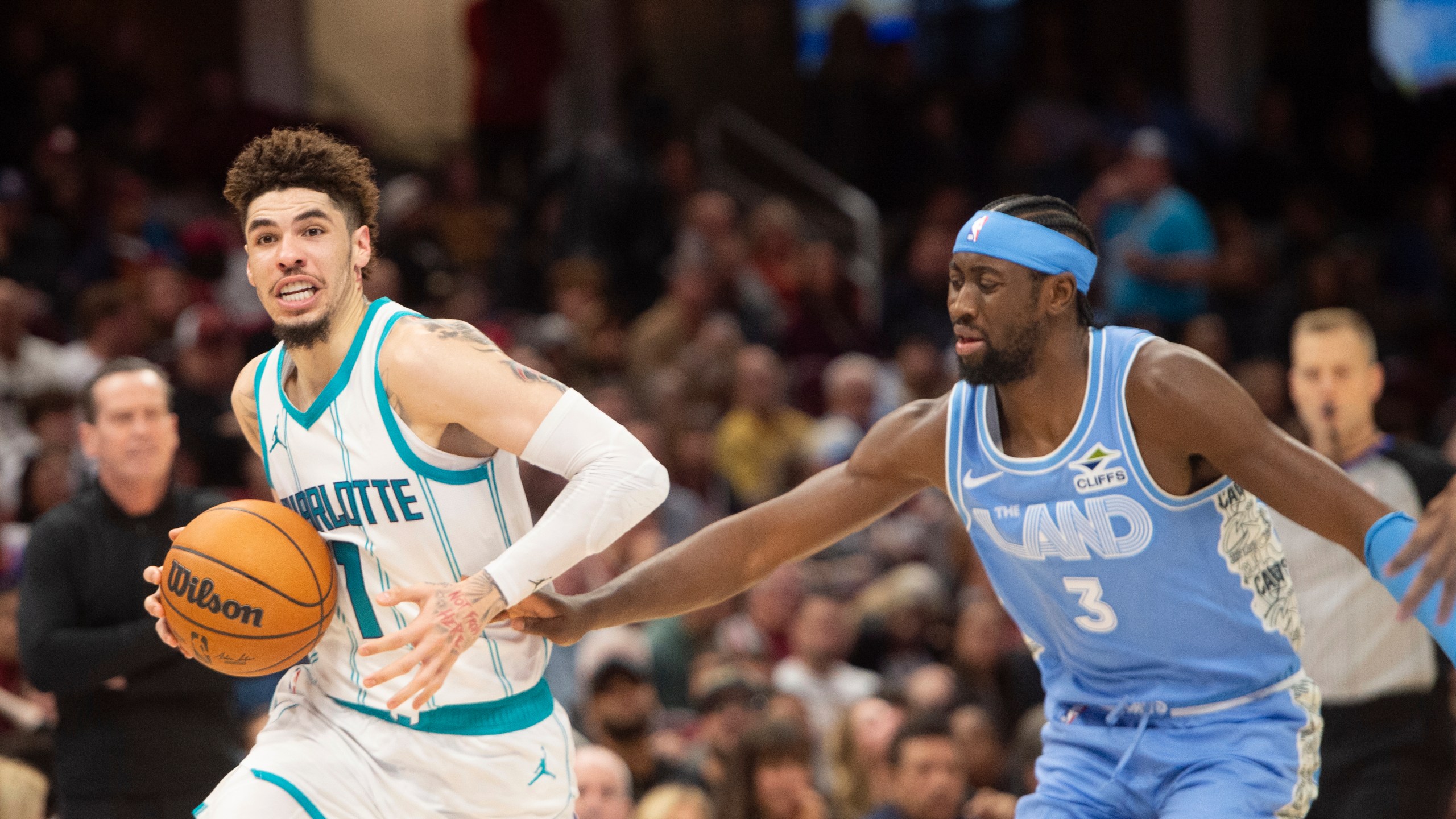 Charlotte Hornets' LaMelo Ball (1) drives past Cleveland Cavaliers' Caris LeVert (3) during the second half of an NBA basketball game in Cleveland, Sunday, Nov 17, 2024. (AP Photo/Phil Long)