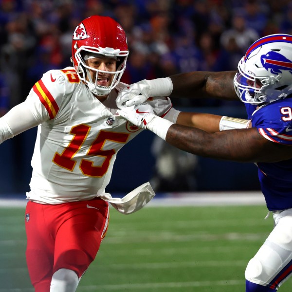 Kansas City Chiefs quarterback Patrick Mahomes (15) scrambles away from Buffalo Bills defensive tackle Jordan Phillips (97) during the second half of an NFL football game Sunday, Nov. 17, 2024, in Orchard Park, N.Y. (AP Photo/Jeffrey T. Barnes)