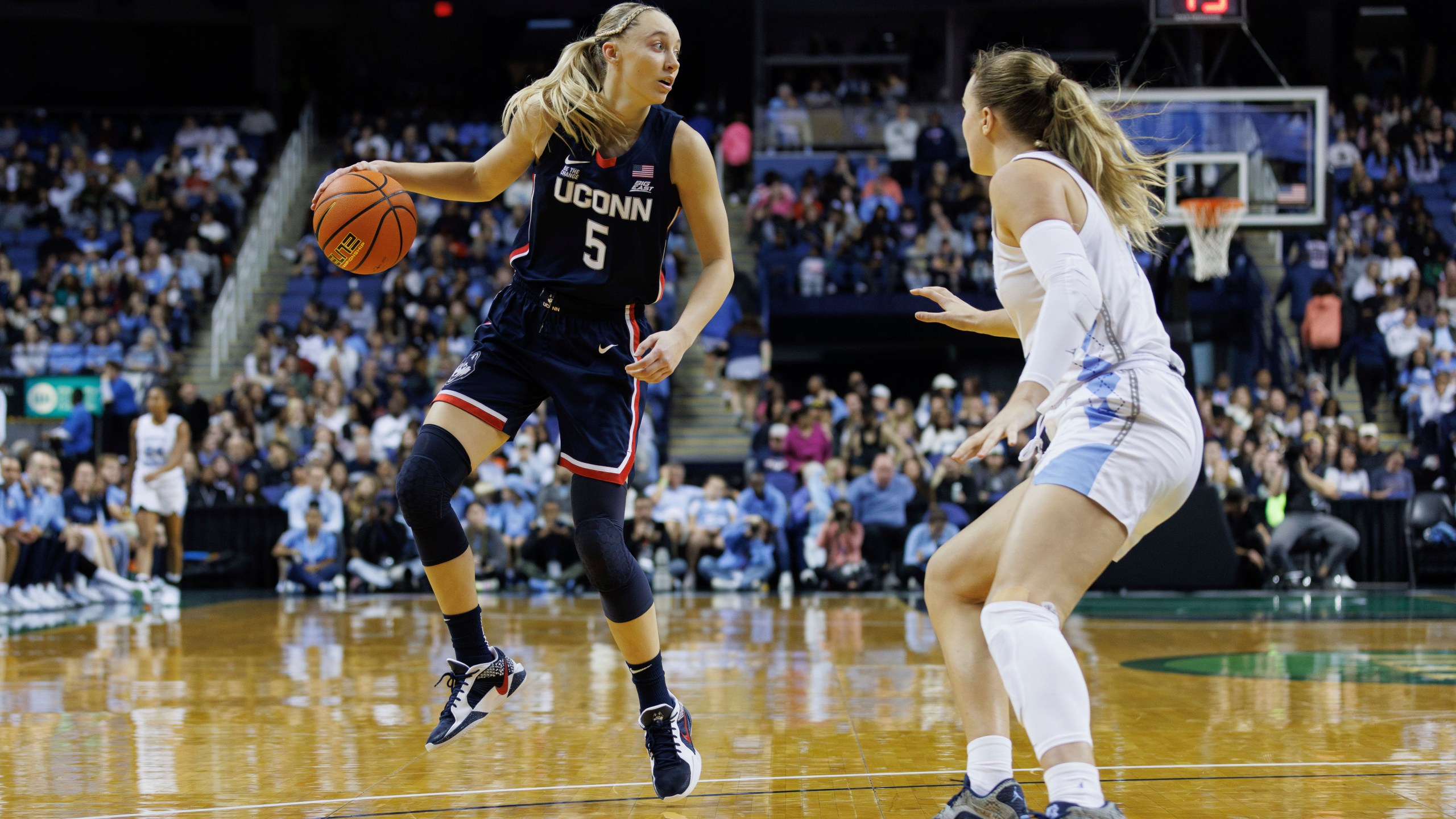 UConn's Paige Bueckers (5) handles the ball as North Carolina's Alyssa Ustby, right, defends during the second half of an NCAA college basketball game in Greensboro, N.C., Friday, Nov. 15, 2024. (AP Photo/Ben McKeown)