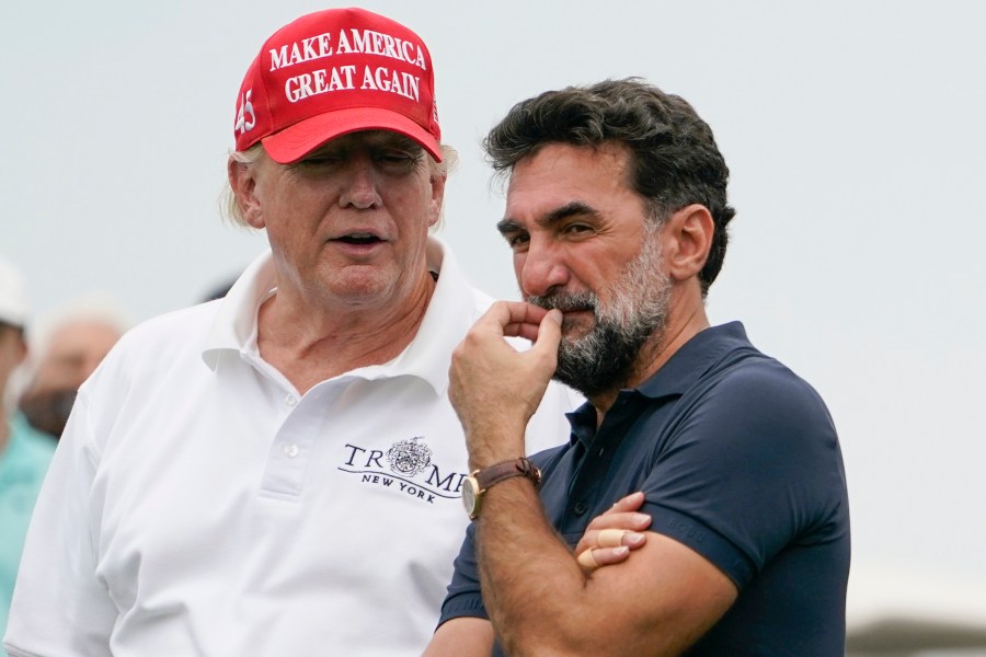 FILE - Former President Donald Trump, left, talks with Yasir Al-Rumayyan, governor of Saudi Arabia's Public Investment Fund, on the 16th hole during the first round of the Bedminster Invitational LIV Golf tournament in Bedminster, NJ., July 29, 2022. (AP Photo/Seth Wenig, File)