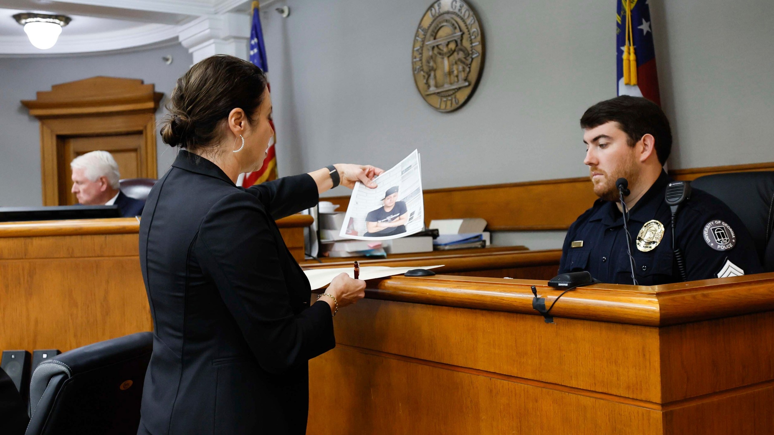 Prosecutor Sheila Ross shows a piece of evidence to University of Georgia Police Josh Epps during the trial of Jose Ibarra at Athens-Clarke County Superior Court on Monday, Nov. 18, 2024, in Athens, Ga. (Miguel Martinez/Atlanta Journal-Constitution via AP, Pool)