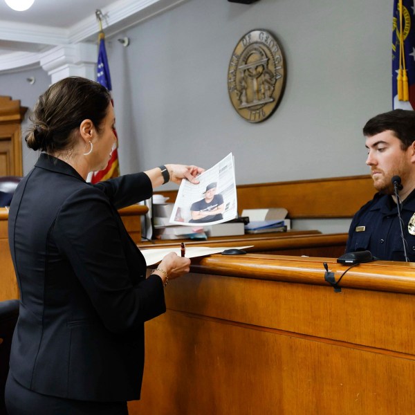 Prosecutor Sheila Ross shows a piece of evidence to University of Georgia Police Josh Epps during the trial of Jose Ibarra at Athens-Clarke County Superior Court on Monday, Nov. 18, 2024, in Athens, Ga. (Miguel Martinez/Atlanta Journal-Constitution via AP, Pool)