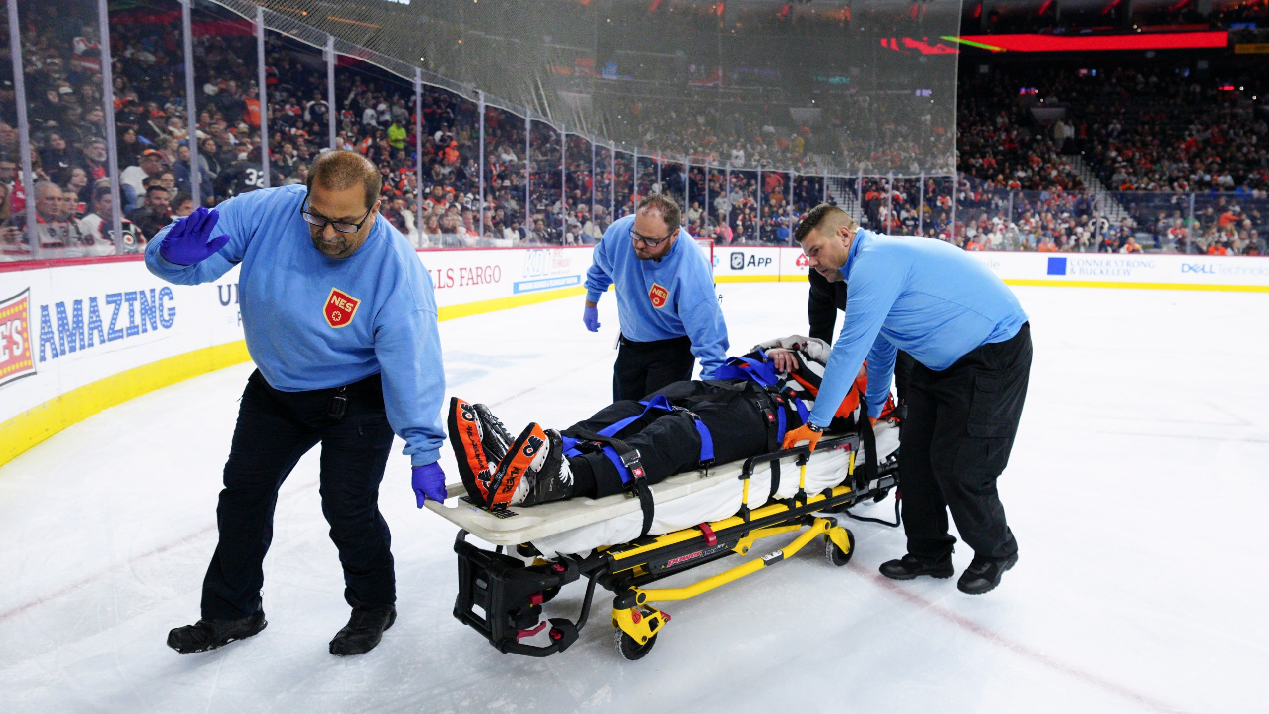 Referee Mitch Dunning, center, is stretchered off the ice after an injury during the first period of an NHL hockey game between the Philadelphia Flyers and the Colorado Avalanche, Monday, Nov. 18, 2024, in Philadelphia. (AP Photo/Derik Hamilton)