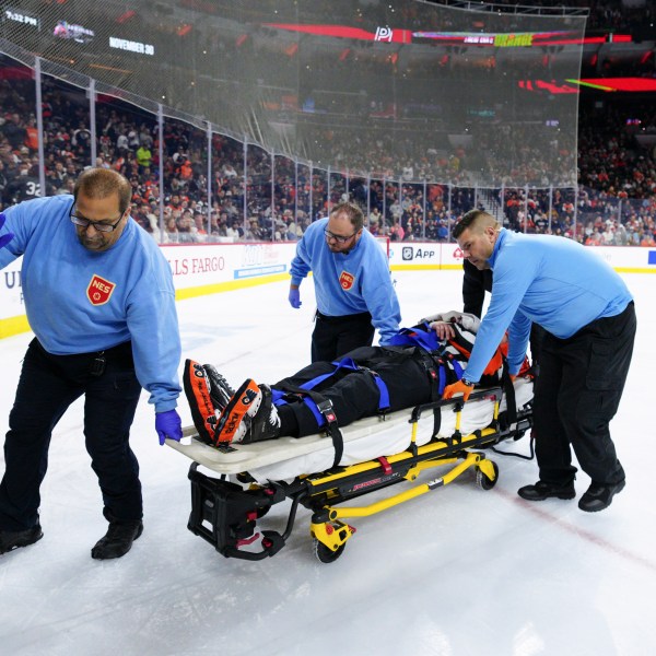 Referee Mitch Dunning, center, is stretchered off the ice after an injury during the first period of an NHL hockey game between the Philadelphia Flyers and the Colorado Avalanche, Monday, Nov. 18, 2024, in Philadelphia. (AP Photo/Derik Hamilton)