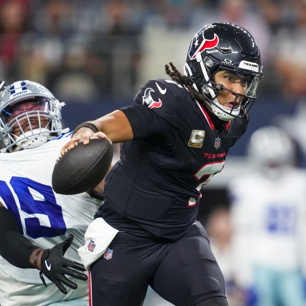 Houston Texans quarterback C.J. Stroud, right, gets help from offensive tackle Laremy Tunsil, left, to escape a tackle attempt by Dallas Cowboys quarterback Trey Lance during the second half of an NFL football game, Monday, Nov. 18, 2024, in Arlington, Texas. (AP Photo/Tony Gutierrez)