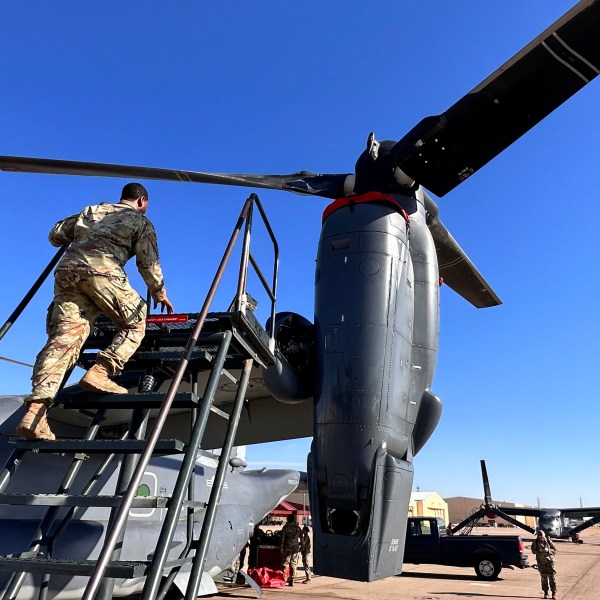 Master Sgt. Frank Williams, the production superintendent of the 20th Special Operations aircraft maintenance squadron at Cannon Air Force Base, N.M., climbs a ladder to show where hydraulic lines at the joint of the rotating engine and transmission need to be checked on the Osprey after flights, Oct. 8, 2024. (AP Photo/Tara Copp)