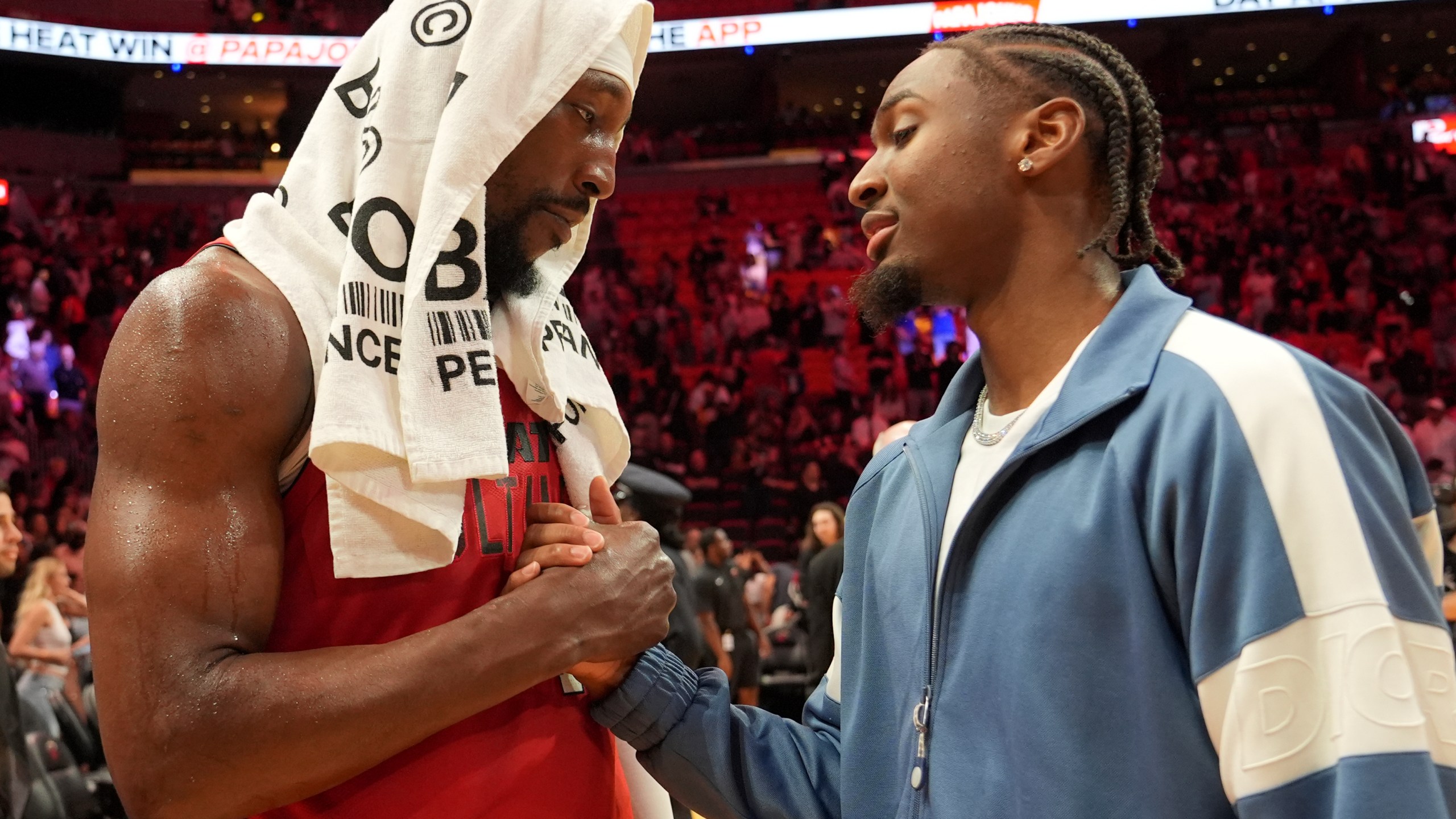 Miami Heat center Bam Adebayo, left, shakes shakes with Philadelphia 76ers guard Tyrese Maxey, right, after an NBA basketball game, Monday, Nov. 18, 2024, in Miami. (AP Photo/Lynne Sladky)