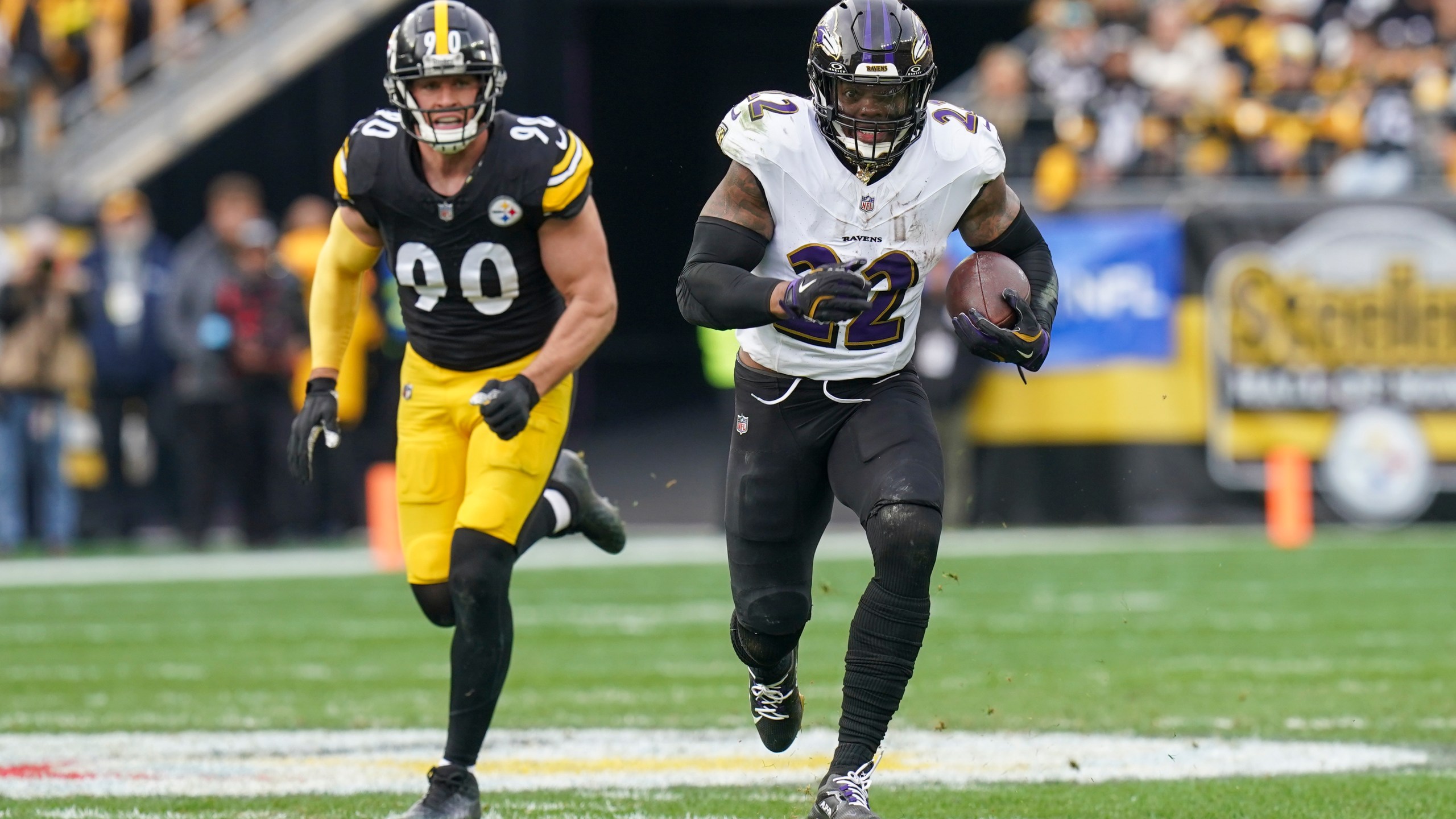 Baltimore Ravens running back Derrick Henry (22) runs with the ball in front of Pittsburgh Steelers linebacker T.J. Watt (90) during the first half of an NFL football game, Sunday, Nov. 17, 2024, in Pittsburgh. (AP Photo/Matt Freed)