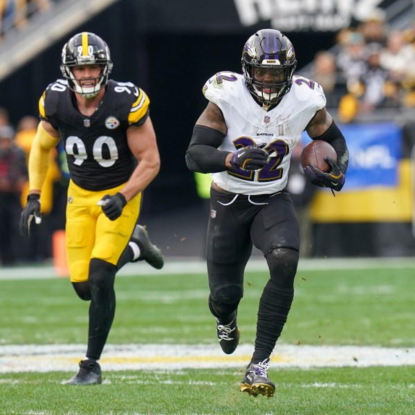 Baltimore Ravens running back Derrick Henry (22) runs with the ball in front of Pittsburgh Steelers linebacker T.J. Watt (90) during the first half of an NFL football game, Sunday, Nov. 17, 2024, in Pittsburgh. (AP Photo/Matt Freed)