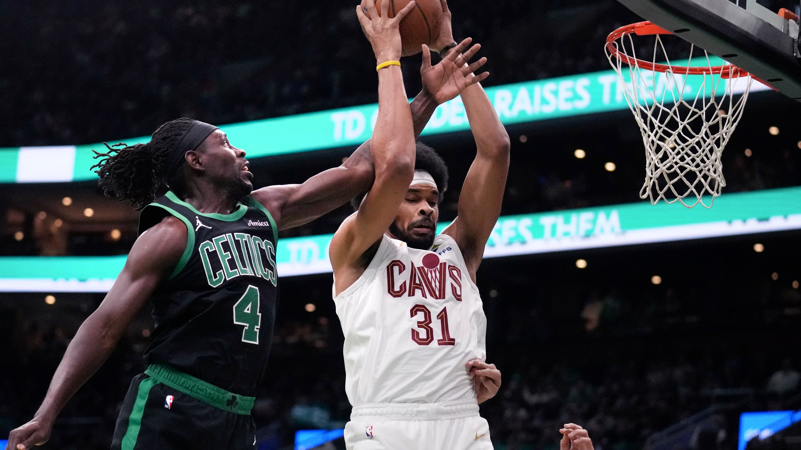 Boston Celtics guard Jrue Holiday (4) battles for a rebound against Cleveland Cavaliers center Jarrett Allen (31) during the first half of an Emirates NBA Cup basketball game, Tuesday, Nov. 19, 2024, in Boston. (AP Photo/Charles Krupa)