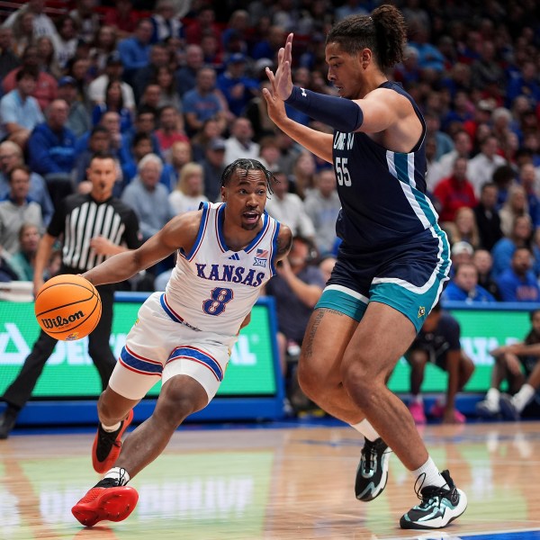 Kansas guard David Coit (8) drives past UNC Wilmington forward Harlan Obioha (55) during the first half of an NCAA college basketball game Tuesday, Nov. 19, 2024, in Lawrence, Kan. (AP Photo/Charlie Riedel)