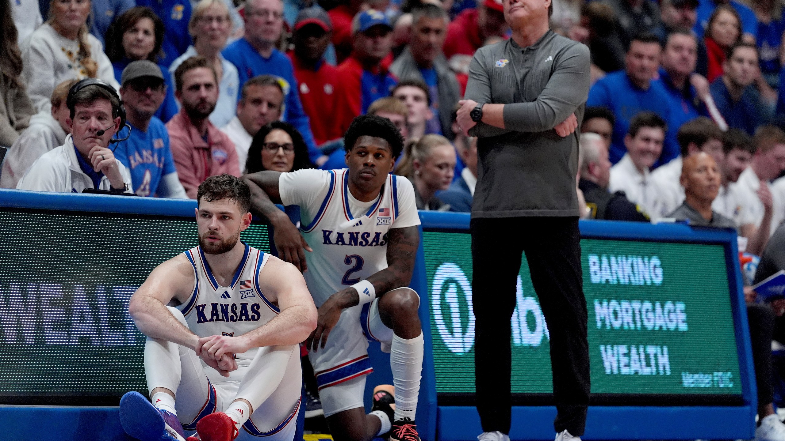 Kansas head coach Bill Self watches with center Hunter Dickinson, left, and guard AJ Storr (2) during the second half of an NCAA college basketball game against UNC Wilmington, Tuesday, Nov. 19, 2024, in Lawrence, Kan. (AP Photo/Charlie Riedel)