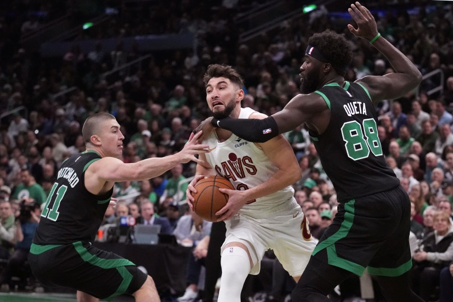 Cleveland Cavaliers guard Ty Jerome, center, tries to drive between Boston Celtics guard Payton Pritchard (11) and center Neemias Queta (88) during the first half of an Emirates NBA Cup basketball game, Tuesday, Nov. 19, 2024, in Boston. (AP Photo/Charles Krupa)