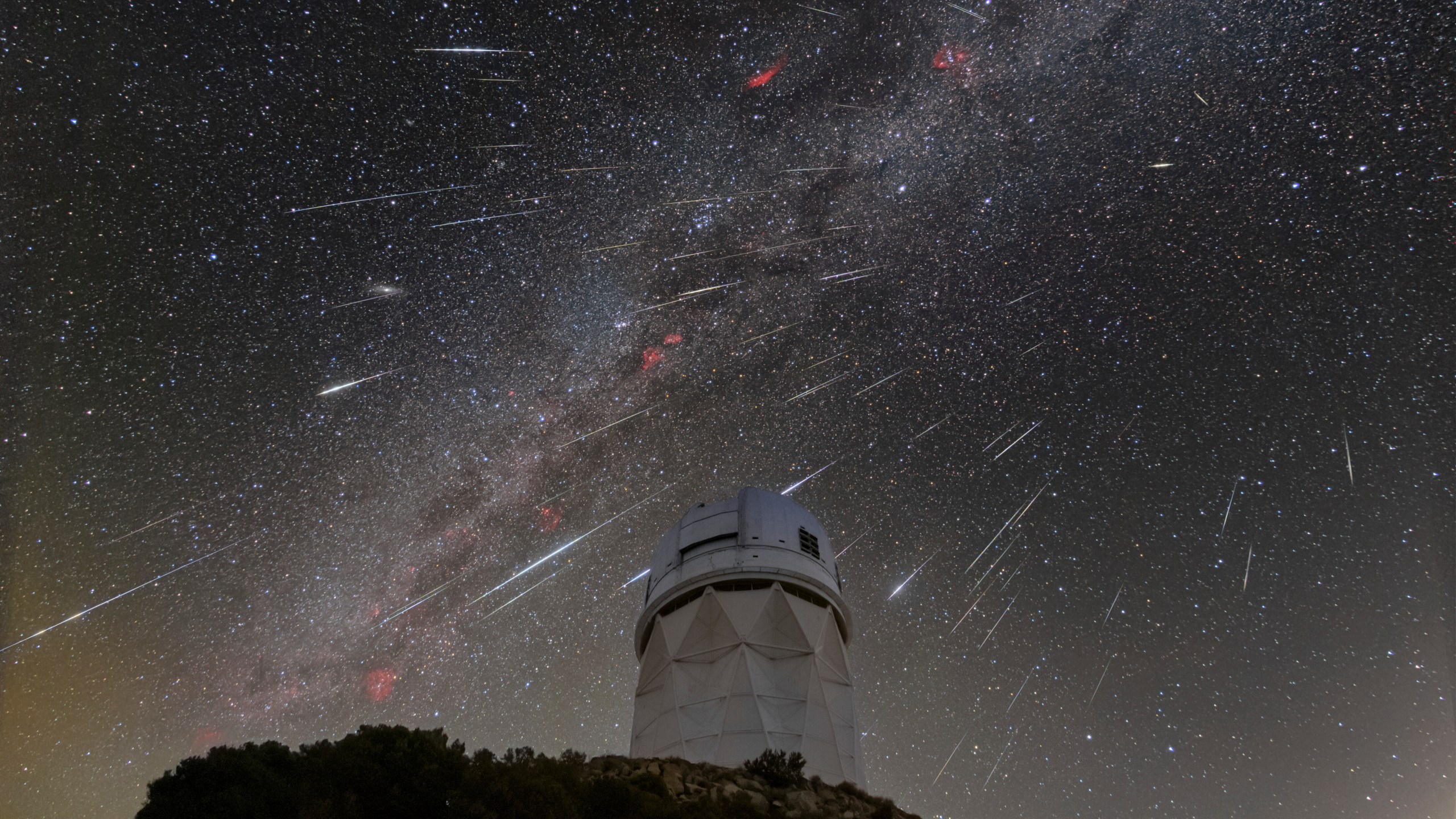 CORRECTS LOCATION TO 56 MILES SOUTHWEST OF TUCSON NOT IN TUCSON This Dec. 14, 2023 image made available by NOIRLab shows meteors from the Geminid meteor shower streaking across the sky above the Nicholas U. Mayall Telescope at Kitt Peak National Observatory (KPNO), a Program of NSF's NOIRLab, located about 56 miles (90 kilometers) southwest of Tucson in the Tohono O’odham Nation. (NSF's NOIRLab via AP)