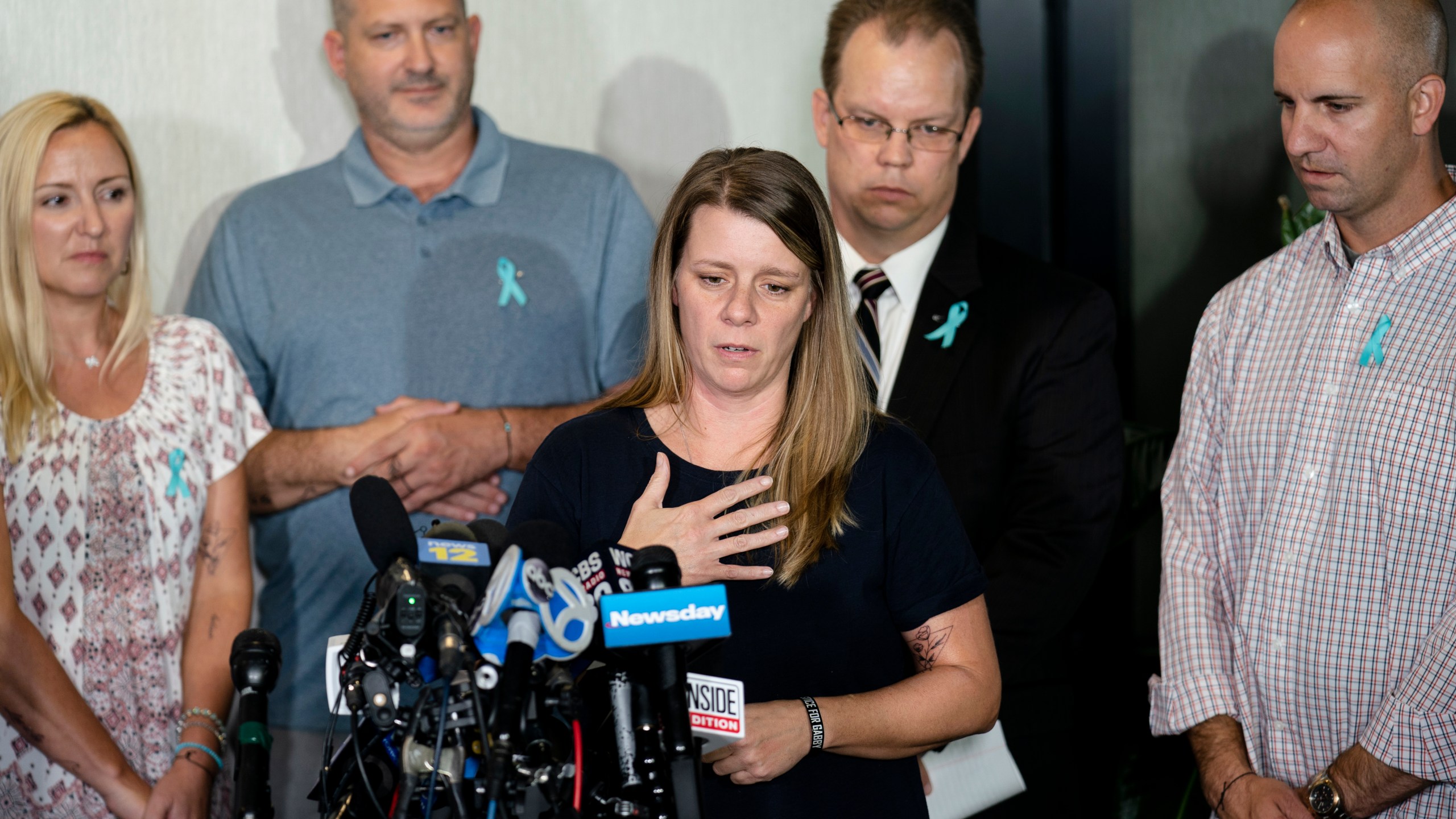 FILE - Nichole Schmidt, mother of Gabby Petito, whose death on a cross-country trip has sparked a manhunt for her boyfriend Brian Laundrie, speaks alongside, from left, Tara Petito, stepmother, Joseph Petito, father, Richard Stafford, family attorney, and Jim Schmidt, stepfather, during a news conference, Sept. 28, 2021, in Bohemia, N.Y. (AP Photo/John Minchillo, File)