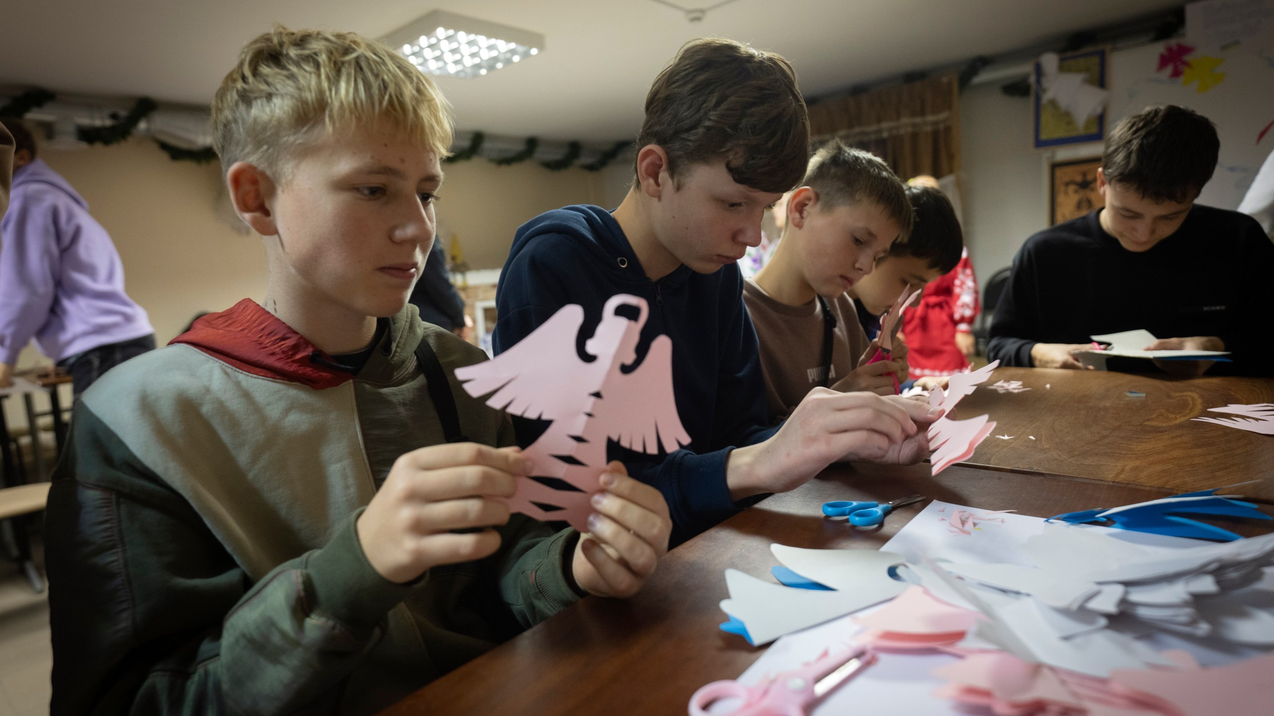 Schoolchildren make decorations for a St. Nicholas Residence and Workshop of Good Deeds in a basement bomb shelter of a military lyceum on World Children's Day in Kyiv, Ukraine, Wednesday, Nov. 20, 2024. (AP Photo/Efrem Lukatsky)