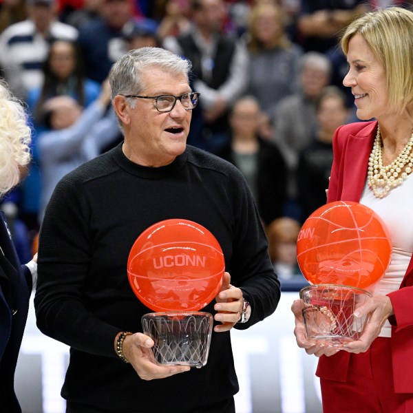 UConn head coach Geno Auriemma and associate head coach Chris Dailey receive recognition from UConn president Radenka Maric, left, during a pregame ceremony honoring Auriemma and longtime assistant Chris Dailey, Wednesday, Nov. 20, 2024, in Storrs, Conn. (AP Photo/Jessica Hill)