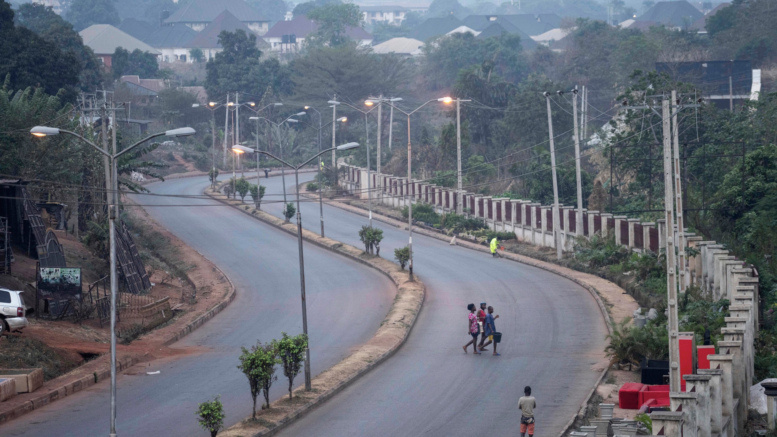 FILE - People walk across a normally packed highway during a separatists imposed lockdown in Enugu, Nigeria, Feb. 14, 2022. (AP Photo/Jerome Delay, File)