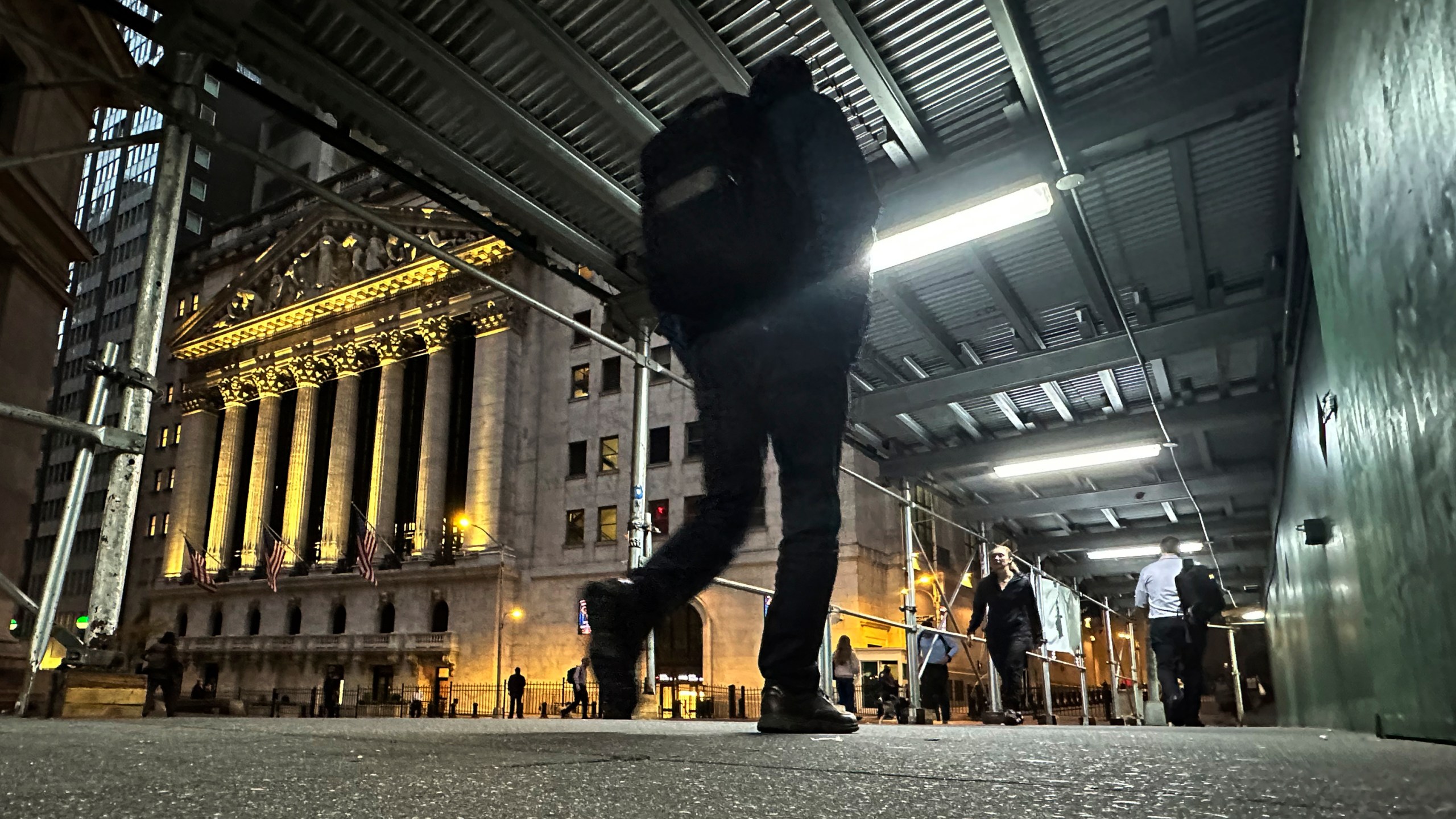 FILE - People walk under a sidewalk shed near the New York Stock Exchange on Oct. 30, 2024. (AP Photo/Peter Morgan, File)