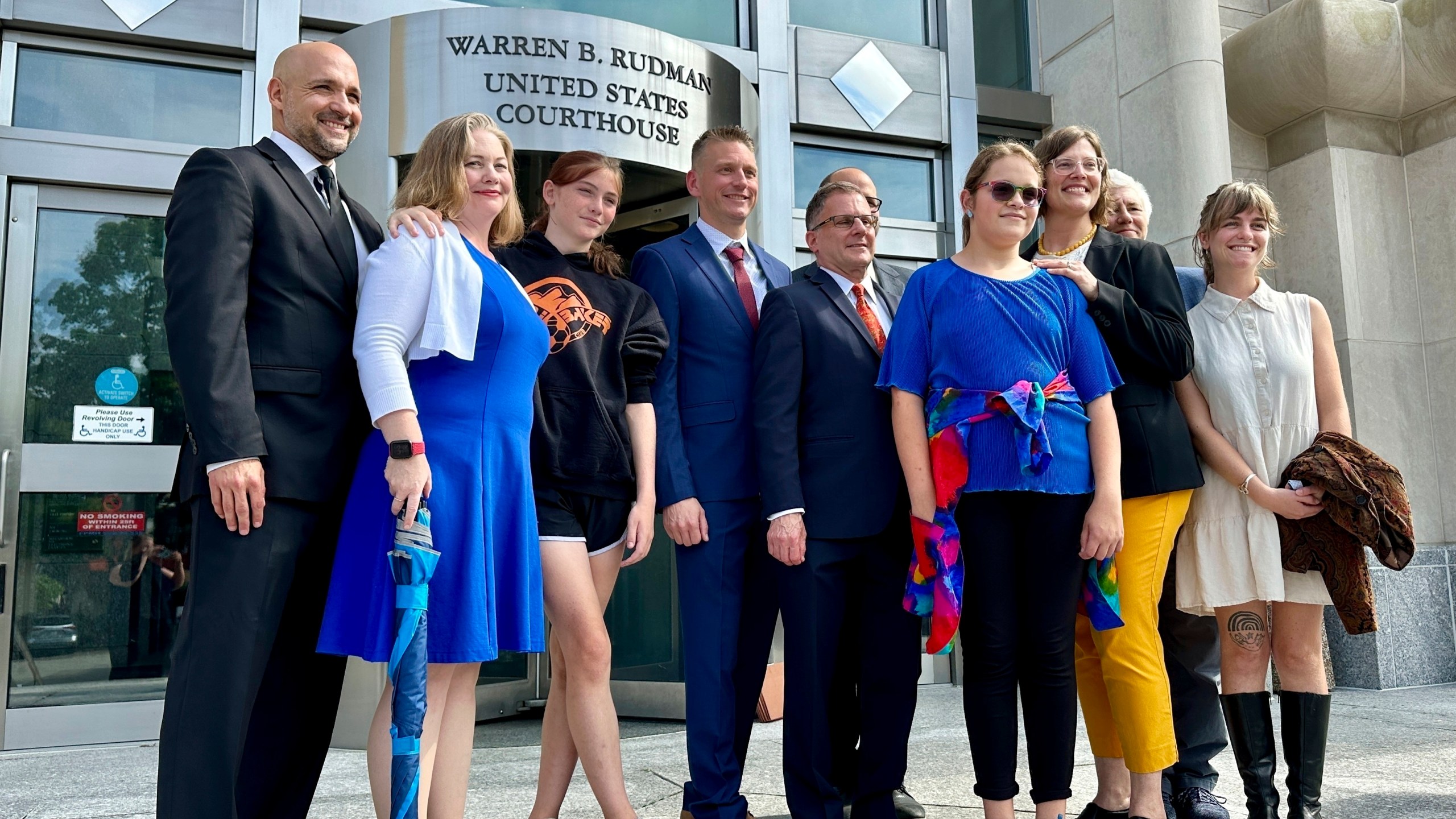 FILE — Two teens challenging New Hampshire's new law banning transgender girls from girls' sports teams, Parker Tirrell, third from left, and Iris Turmelle, sixth from left, pose with their families and attorneys in Concord, N.H., Monday, Aug. 19, 2024. (AP Photo/Holly Ramer, File)