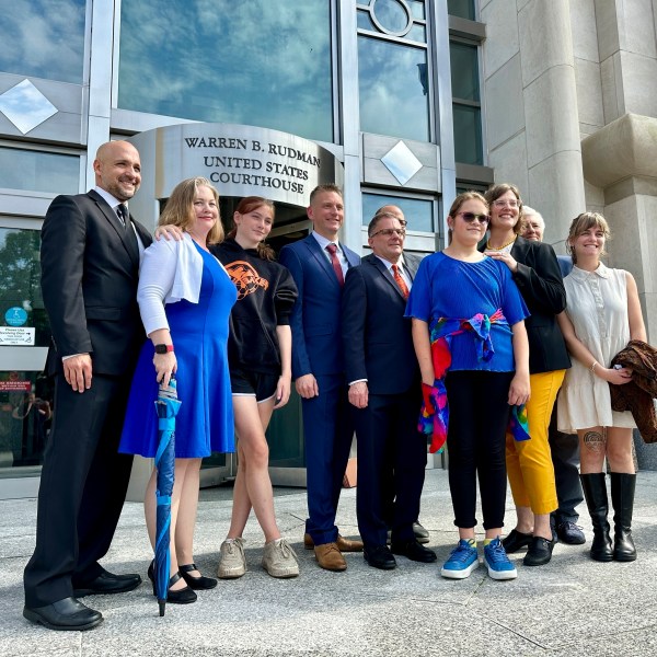 FILE — Two teens challenging New Hampshire's new law banning transgender girls from girls' sports teams, Parker Tirrell, third from left, and Iris Turmelle, sixth from left, pose with their families and attorneys in Concord, N.H., Monday, Aug. 19, 2024. (AP Photo/Holly Ramer, File)