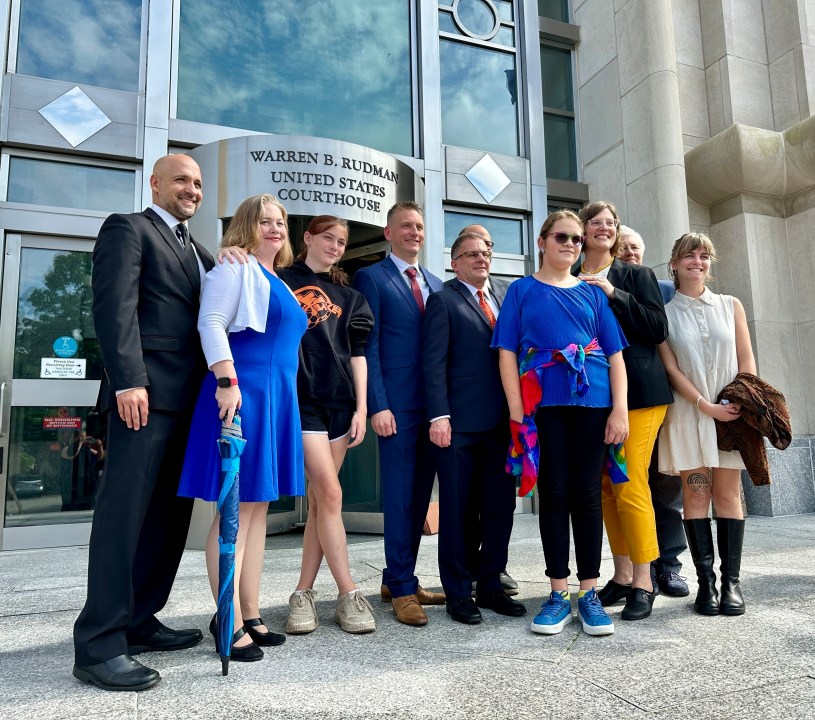 FILE — Two teens challenging New Hampshire's new law banning transgender girls from girls' sports teams, Parker Tirrell, third from left, and Iris Turmelle, sixth from left, pose with their families and attorneys in Concord, N.H., Monday, Aug. 19, 2024. (AP Photo/Holly Ramer, File)