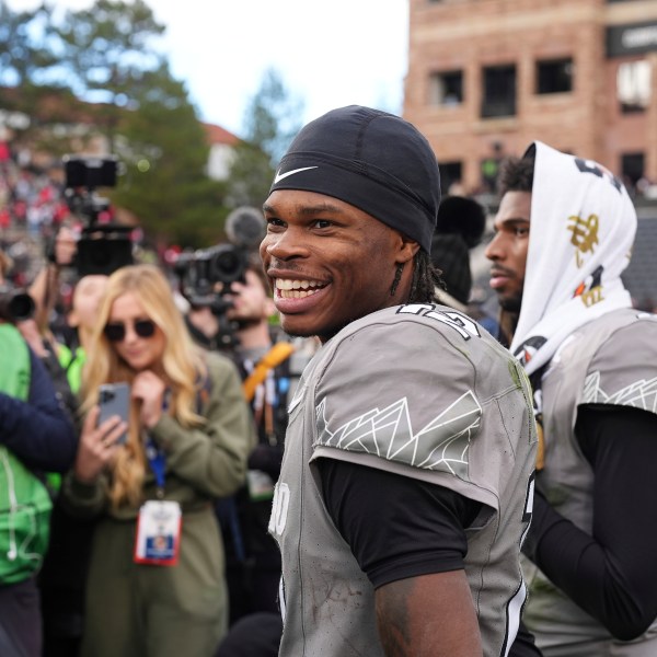 Colorado wide receiver Travis Hunter, front, jokes with teammates as he waits with quarterback Shedeur Sanders to do a television interview after an NCAA college football game against Utah Saturday, Nov. 16, 2024, in Boulder, Colo. (AP Photo/David Zalubowski)