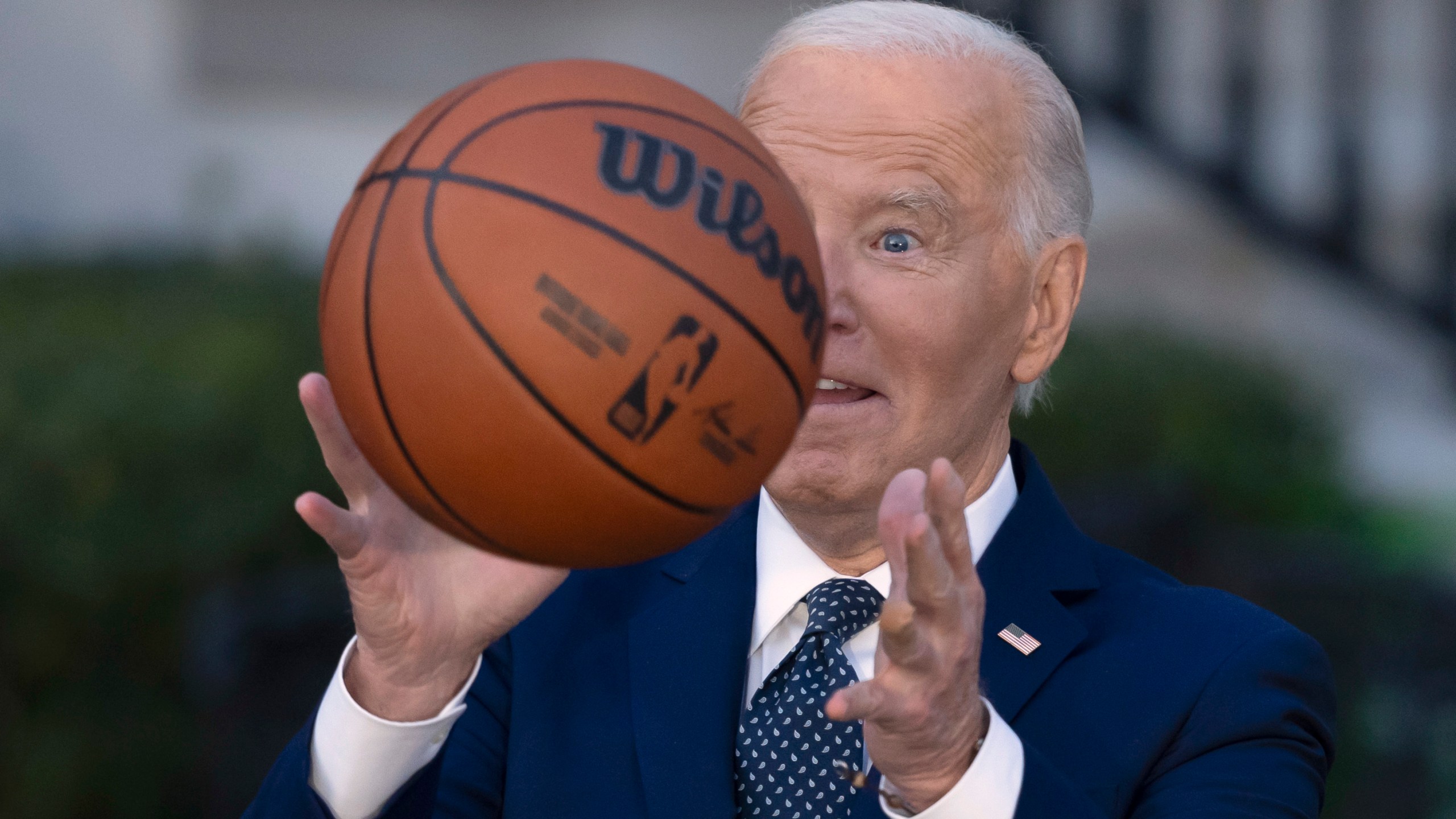 President Joe Biden throws a basketball he received from the Boston Celtics at an event to celebrate the team's victory in the 2024 National Basketball Association Championship, on the South Lawn of the White House in Washington, Thursday, Nov. 21, 2024. (AP Photo/Ben Curtis)