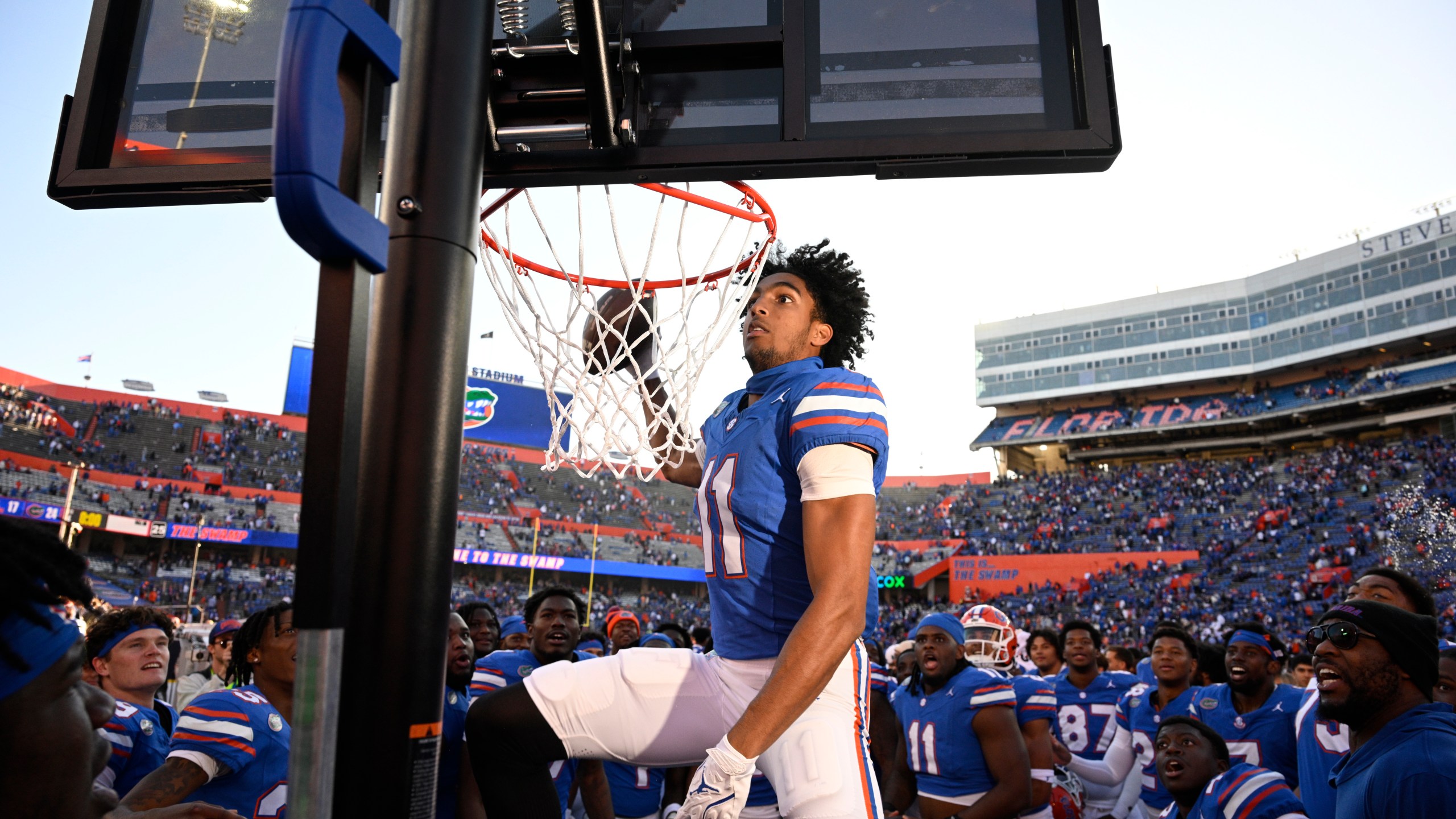 Florida wide receiver Aidan Mizell (11) performs a celebratory dunk using a basketball backboard placed on the Mississippi sideline after their 24-17 win in an NCAA college football game, Saturday, Nov. 23, 2024, in Gainesville, Fla. (AP Photo/Phelan M. Ebenhack)