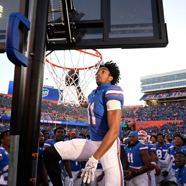 Florida wide receiver Aidan Mizell (11) performs a celebratory dunk using a basketball backboard placed on the Mississippi sideline after their 24-17 win in an NCAA college football game, Saturday, Nov. 23, 2024, in Gainesville, Fla. (AP Photo/Phelan M. Ebenhack)