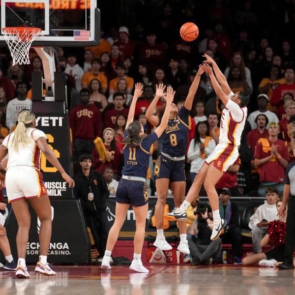 Southern California guard JuJu Watkins (12) shoots over Notre Dame guards Cassandre Prosper (8) and Sonia Citron (11) during the first half of an NCAA college basketball game, Saturday, Nov. 23, 2024 in Los Angeles. (AP Photo/Eric Thayer)