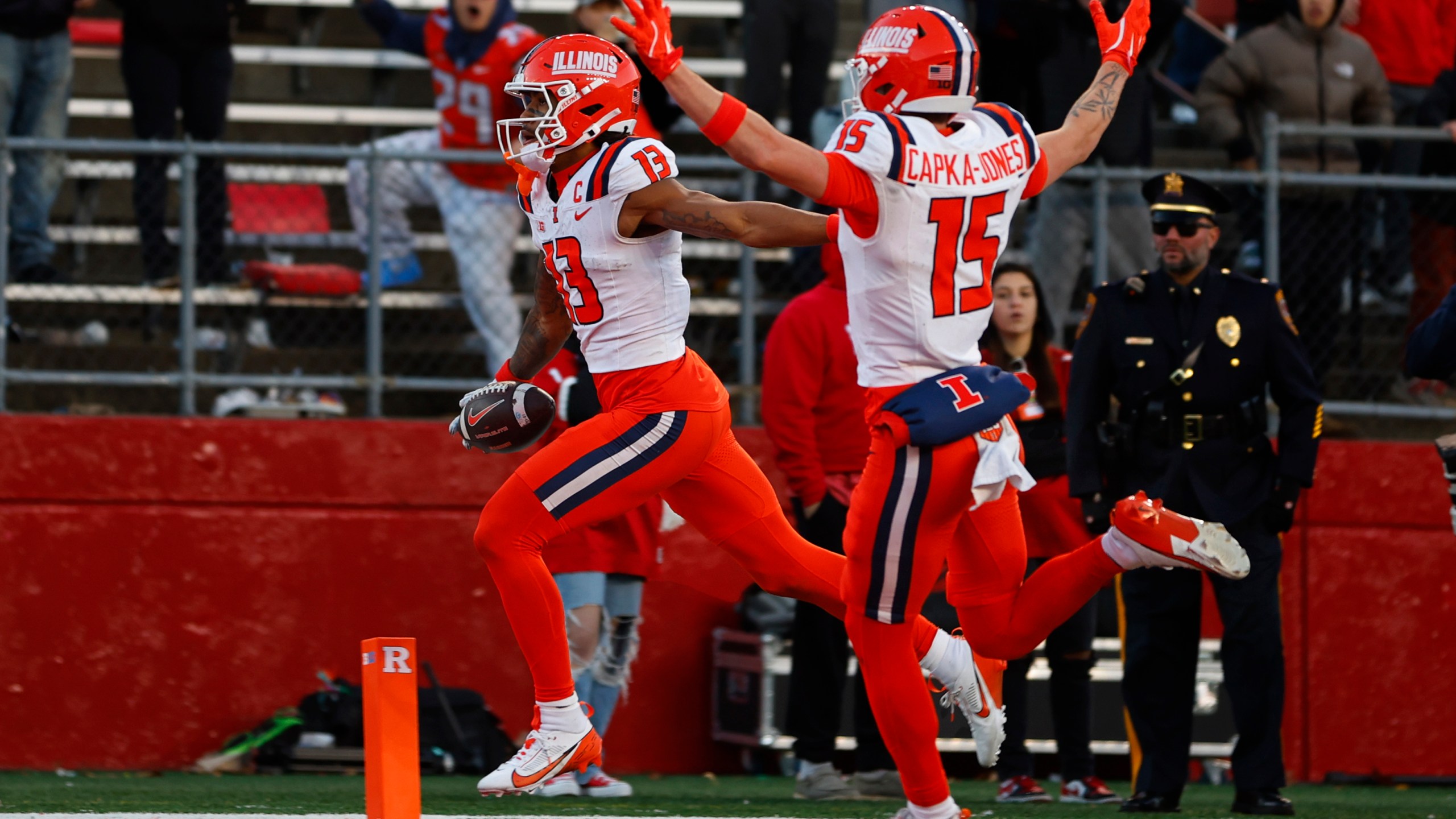 Illinois wide receiver Pat Bryant (13) scores a 40-yard touchdown after making a catch as teammate Alexander Capka-Jones (15) celebrates in the final seconds of an NCAA college football game against Rutgers, Saturday, Nov. 23, 2024, in Piscataway, N.J. Illinois defeated Rutgers 38-31. (AP Photo/Rich Schultz)