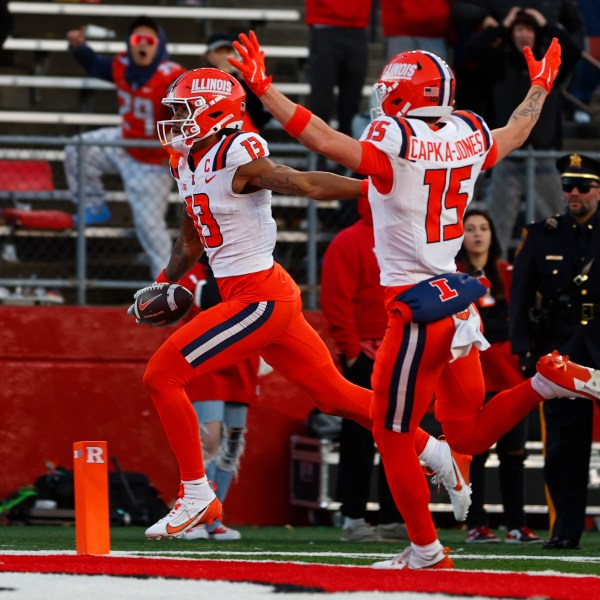 Illinois wide receiver Pat Bryant (13) scores a 40-yard touchdown after making a catch as teammate Alexander Capka-Jones (15) celebrates in the final seconds of an NCAA college football game against Rutgers, Saturday, Nov. 23, 2024, in Piscataway, N.J. Illinois defeated Rutgers 38-31. (AP Photo/Rich Schultz)