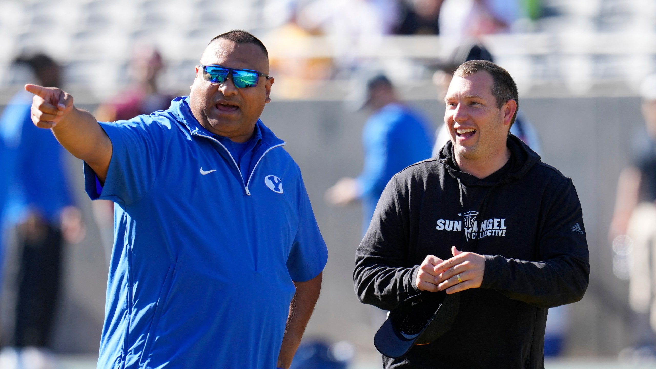 BYU head coach Kalani Sitake, left, talks with Arizona State head coach Kenny Dillingham before an NCAA college football game Saturday, Nov. 23, 2024, in Tempe, Ariz. (AP Photo/Ross D. Franklin)