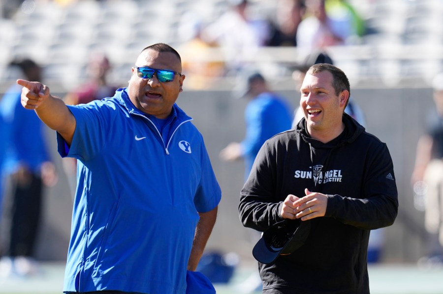 BYU head coach Kalani Sitake, left, talks with Arizona State head coach Kenny Dillingham before an NCAA college football game Saturday, Nov. 23, 2024, in Tempe, Ariz. (AP Photo/Ross D. Franklin)