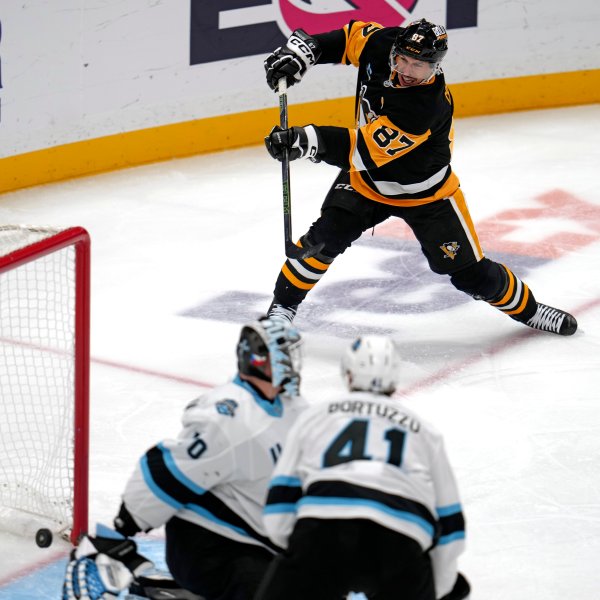 Pittsburgh Penguins' Sidney Crosby (87) gets a shot behind Utah Hockey Club goaltender Karel Vejmelka (70) for his 600th career goal in the NHL during the second period of an NHL hockey game Saturday, Nov. 23, 2024, in Pittsburgh. (AP Photo/Gene J. Puskar)