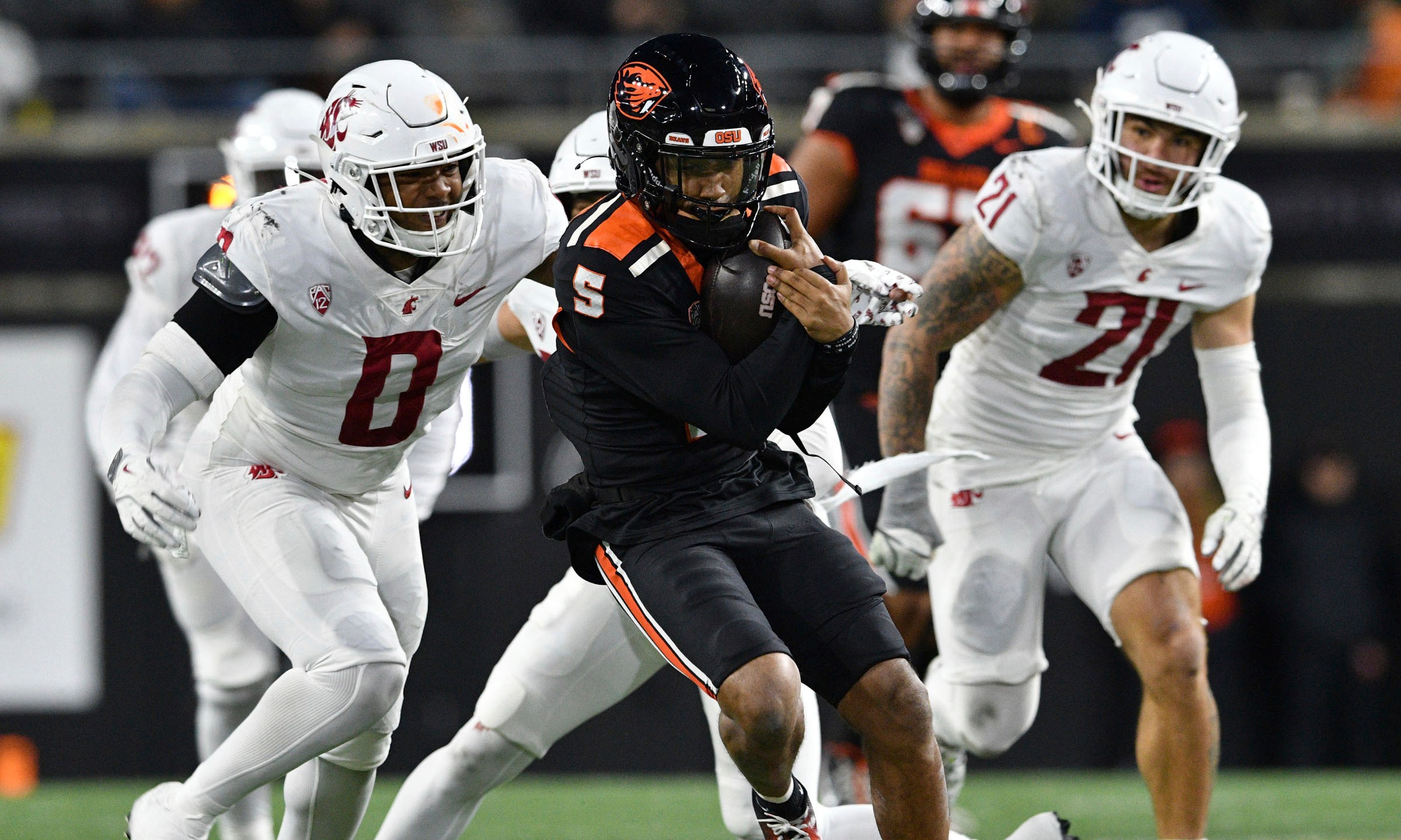 Washington State linebacker Taariq Al-Uqdah (0) pursues Oregon State quarterback Gabarri Johnson (5) during the first half of an NCAA college football game Saturday, Nov. 23, 2024, in Corvallis, Ore. (AP Photo/Mark Ylen)