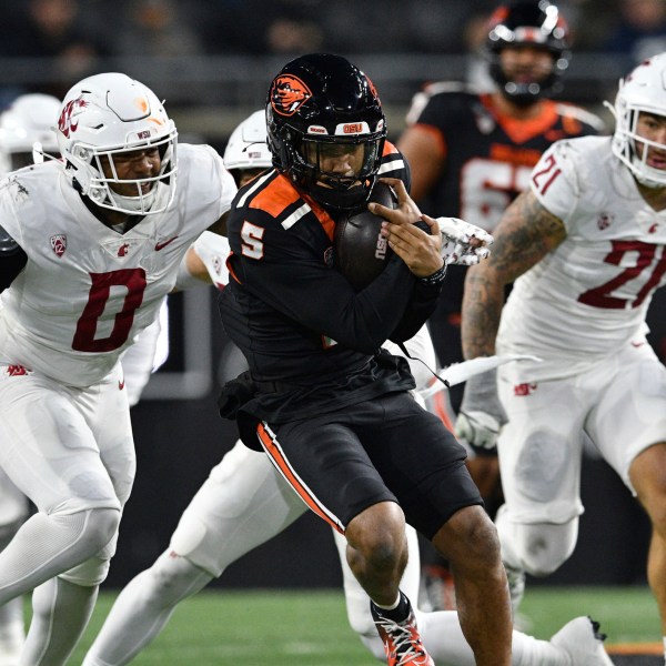 Washington State linebacker Taariq Al-Uqdah (0) pursues Oregon State quarterback Gabarri Johnson (5) during the first half of an NCAA college football game Saturday, Nov. 23, 2024, in Corvallis, Ore. (AP Photo/Mark Ylen)