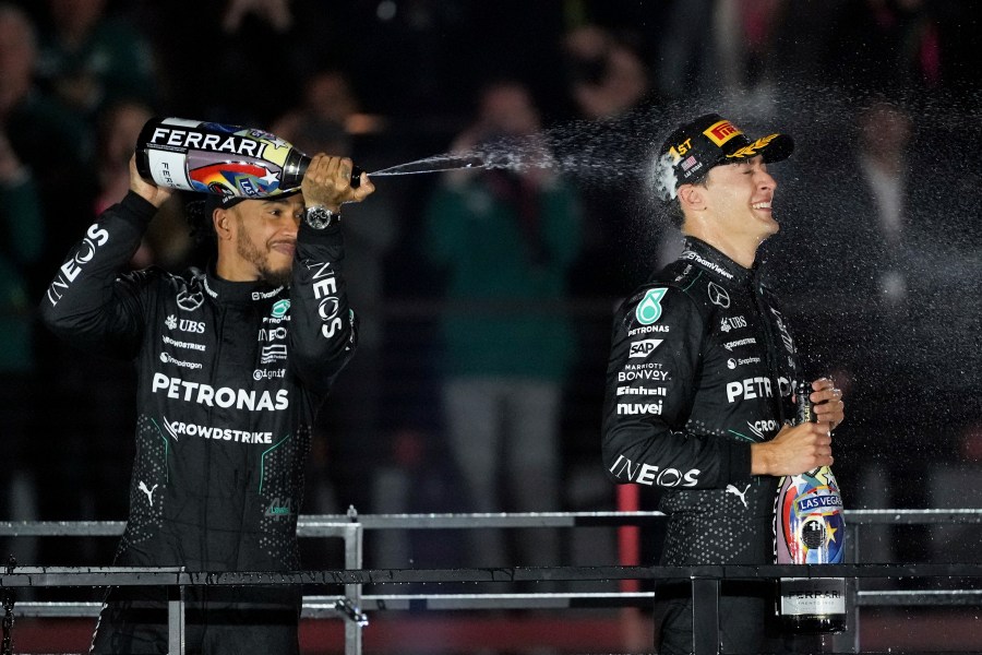 Mercedes driver Lewis Hamilton, of Britain, left, sprays champagne on race winner Mercedes driver George Russell, of Britain, after the F1 Las Vegas Grand Prix auto race, Saturday, Nov. 23, 2024, in Las Vegas. (AP Photo/Rick Scuteri)