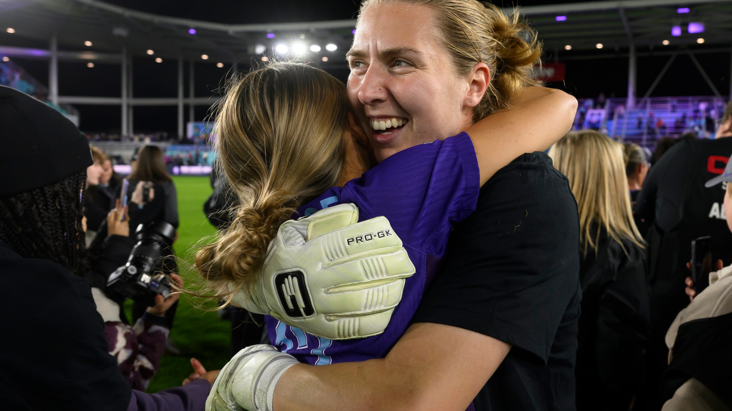 Orlando Pride goalkeeper Anna Moorhouse, right, hugs Pride defender Carrie Lawrence after they defeated the Washington Spirit in the NWSL championship soccer game at CPKC Stadium, Saturday, Nov. 23, 2024, in Kansas City, Mo. (AP Photo/Reed Hoffmann)