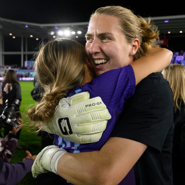 Orlando Pride goalkeeper Anna Moorhouse, right, hugs Pride defender Carrie Lawrence after they defeated the Washington Spirit in the NWSL championship soccer game at CPKC Stadium, Saturday, Nov. 23, 2024, in Kansas City, Mo. (AP Photo/Reed Hoffmann)