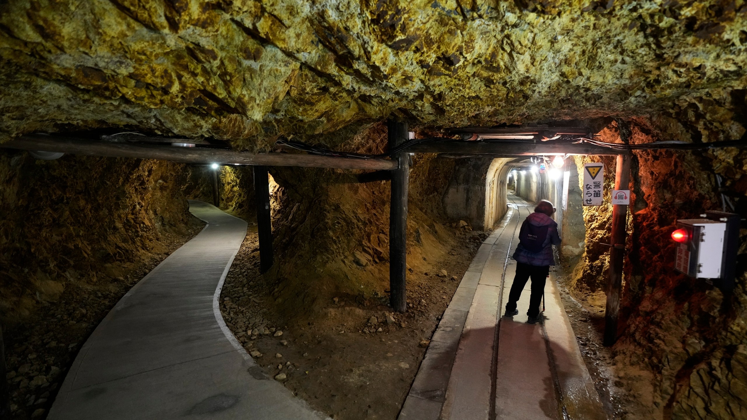 A visitor walk through tunnels at Sado Kinzan Gold Mine historic site in Sado, Niigata prefecture, Japan, Sunday, Nov. 24, 2024. (AP Photo/Eugene Hoshiko)