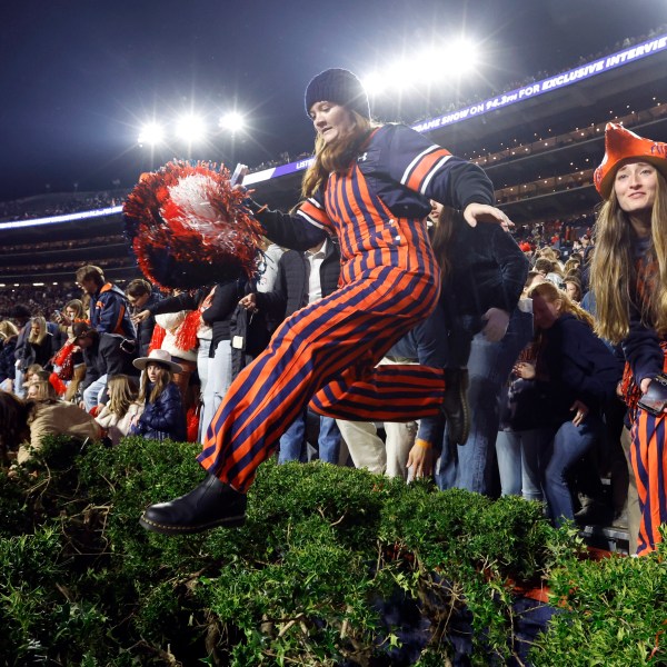 Auburn fans storm the field after defeating Texas A&M during the fourth overtime of an NCAA college football game, Saturday, Nov. 23, 2024, in Auburn, Ala. (AP Photo/Butch Dill)