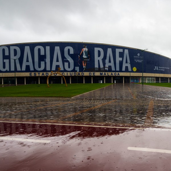 A man walks in front a banner reading in Spanish: "Thank you Rafa" during the Billie Jean King Cup finals at the Martin Carpena sportshall in Malaga, southern Spain, Wednesday, Nov. 13, 2024, after today's matches were canceled due to heavy rain and postponed until tomorrow. (AP Photo/Manu Fernandez)