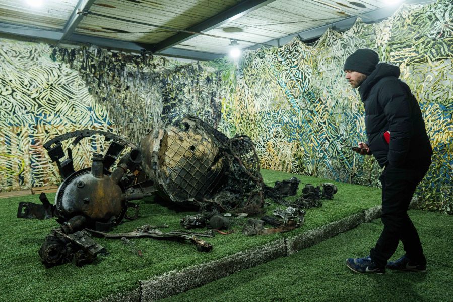 A journalist looks on fragments of a rocket which struck Dnipro on November 21, at a center for forensic analysis in undisclosed location, Ukraine, Sunday Nov. 24, 2024. (AP Photo/Evgeniy Maloletka)